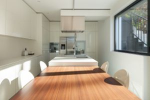 cozinha estreita, móveis branca e mesa de refeições